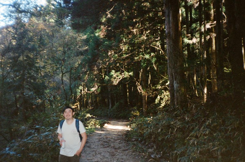 A photo of a man in the forest, smiling