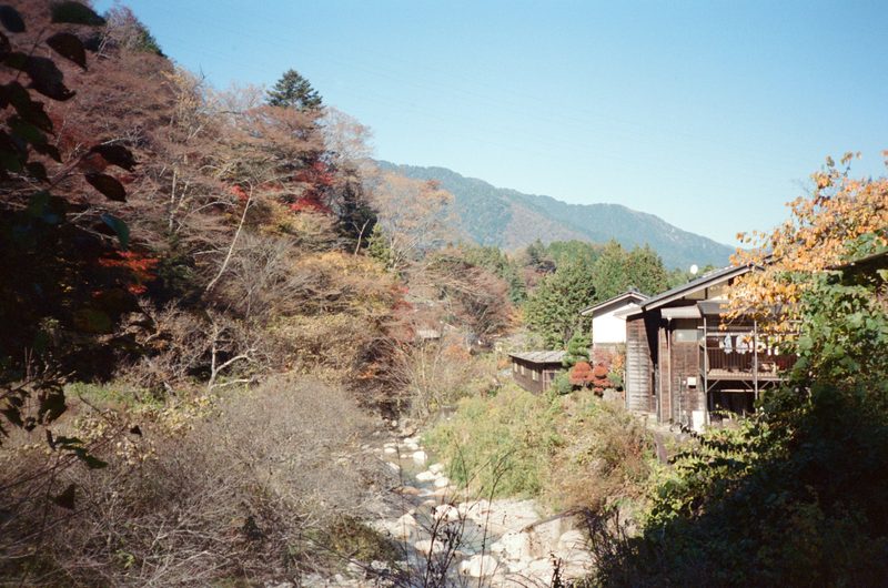 A photo of the mountains in the background with a river running in the foreground