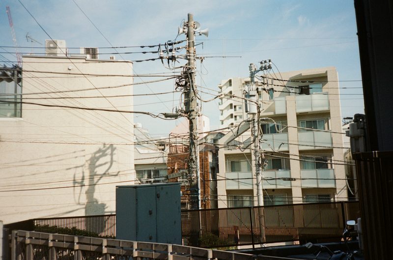 A photo of a streetscape, with wires hanging from building to building'